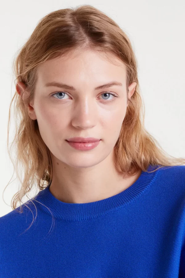 Blue flared knit sweaterBlue flared knit sweater with a round neck and long sleeves.